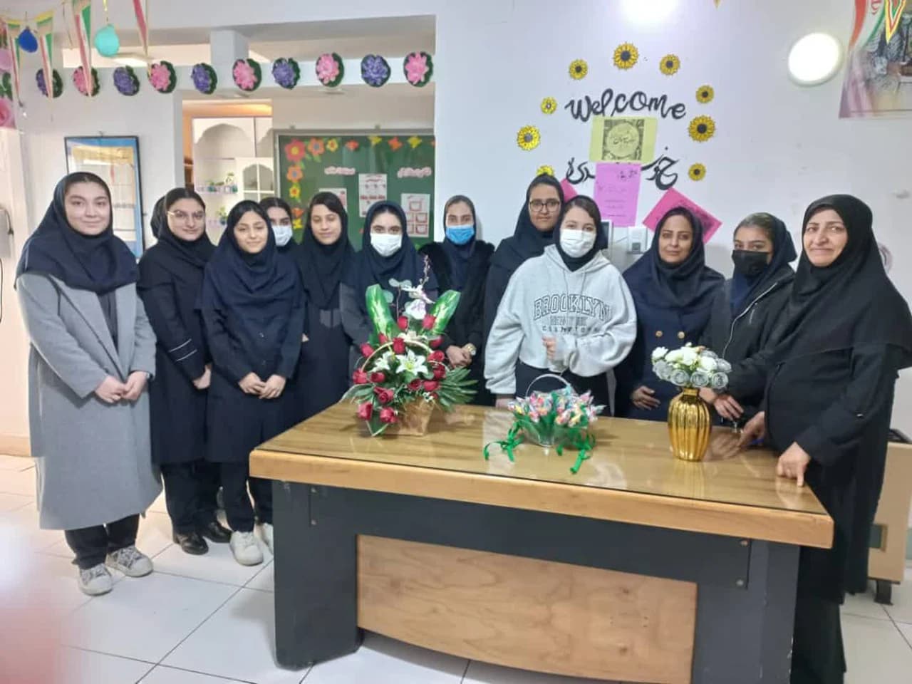 دورهمی گروهی دانشآموزان و کادر مدرسه با تزئینات گل